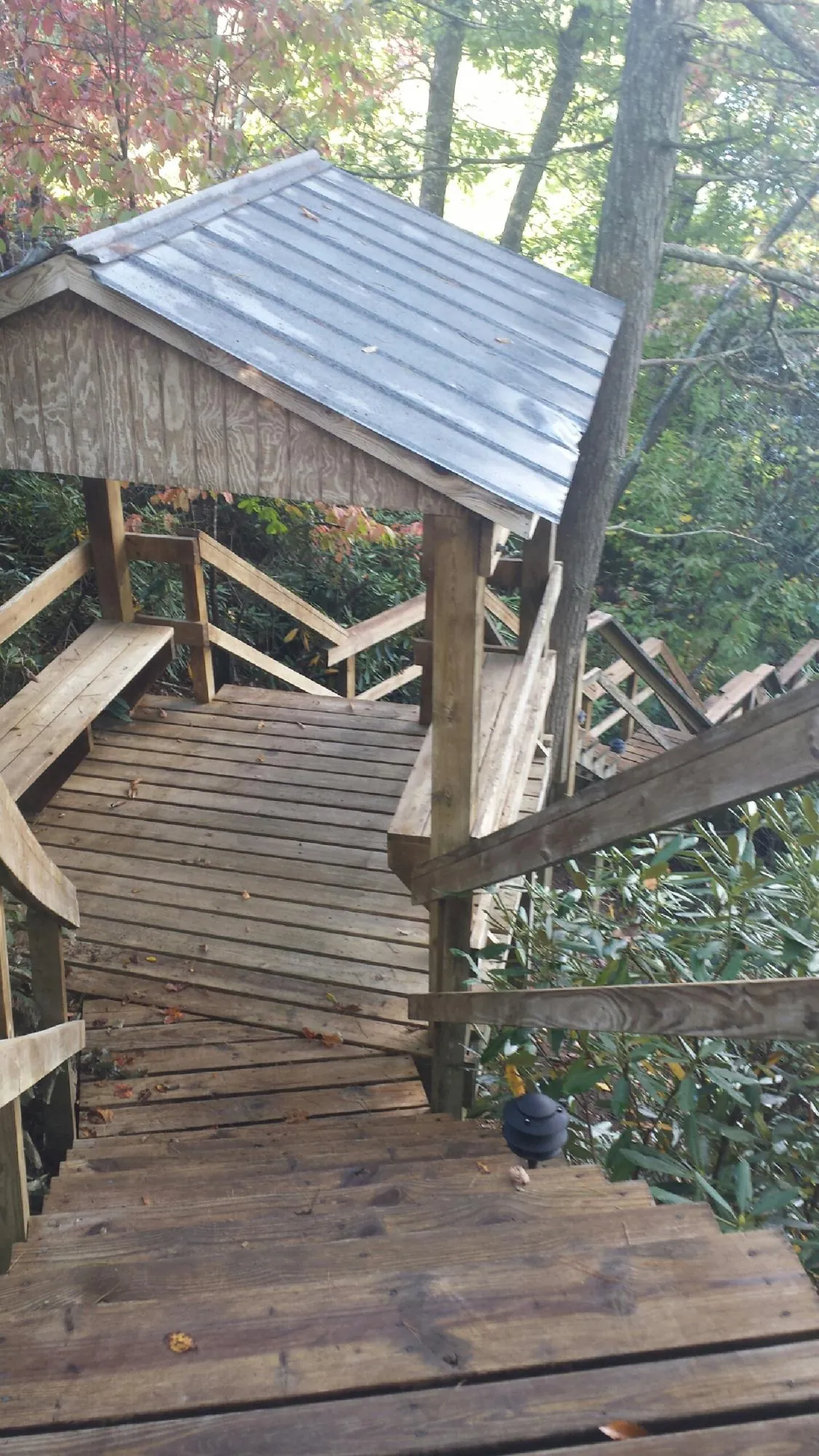 Metal roofed shelter over wooden steps on a wooded walkway — Skylight Repair & Installation work by our crew in Refton